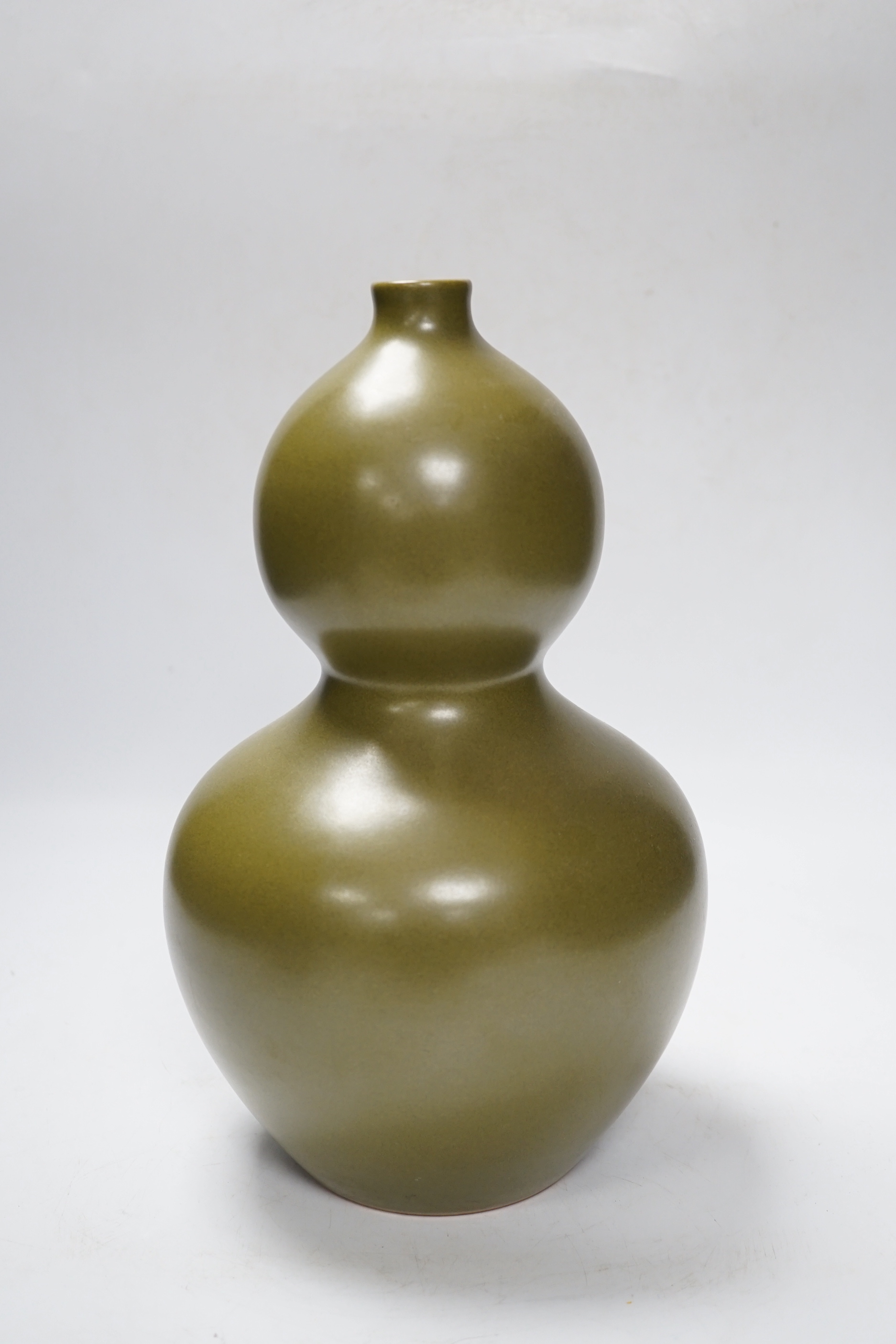A Chinese olive-green double gourd vase, 29cm high